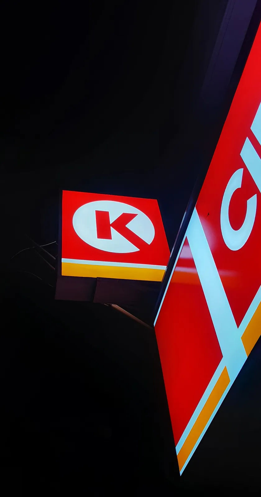 Biển hiệu Circle K sáng đèn trong đêm, nhìn từ dưới lên