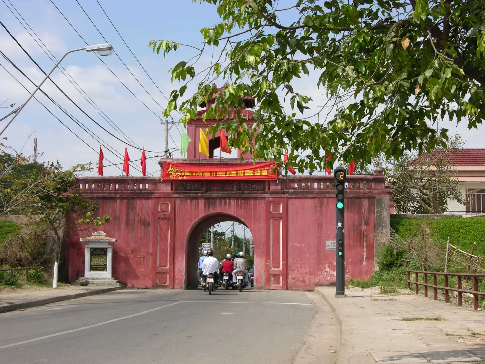 Cổng Đông thành cổ Diên Khánh, tường gạch đỏ và cờ trên vọng lâu