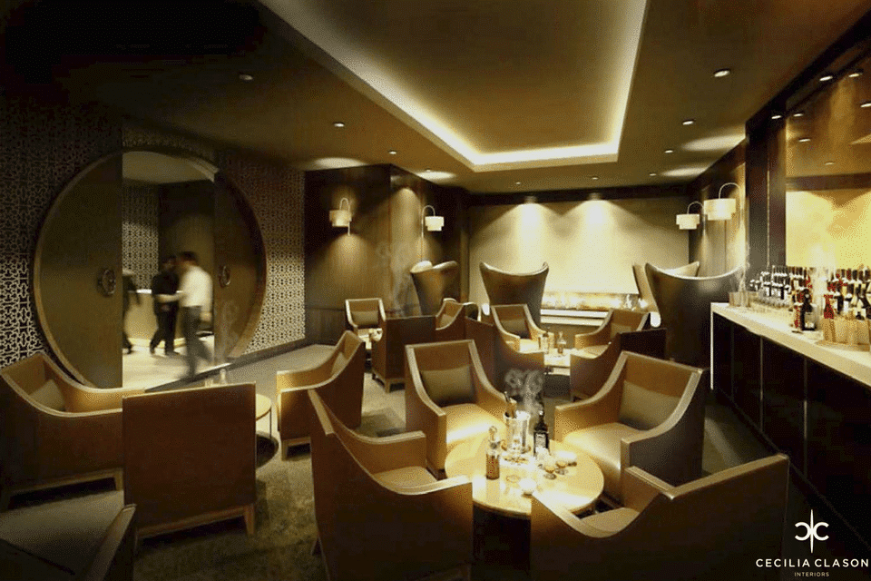 Cigar Lounge - Coffered ceiling & ceiling lights above luxury furniture, wall lamps with circular door in feature wall