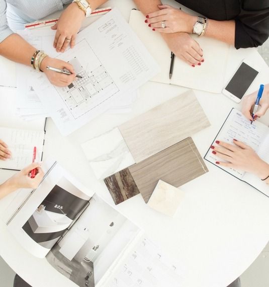 Cecilia Clason & Interior Designers planning around a table with their materials & notebooks