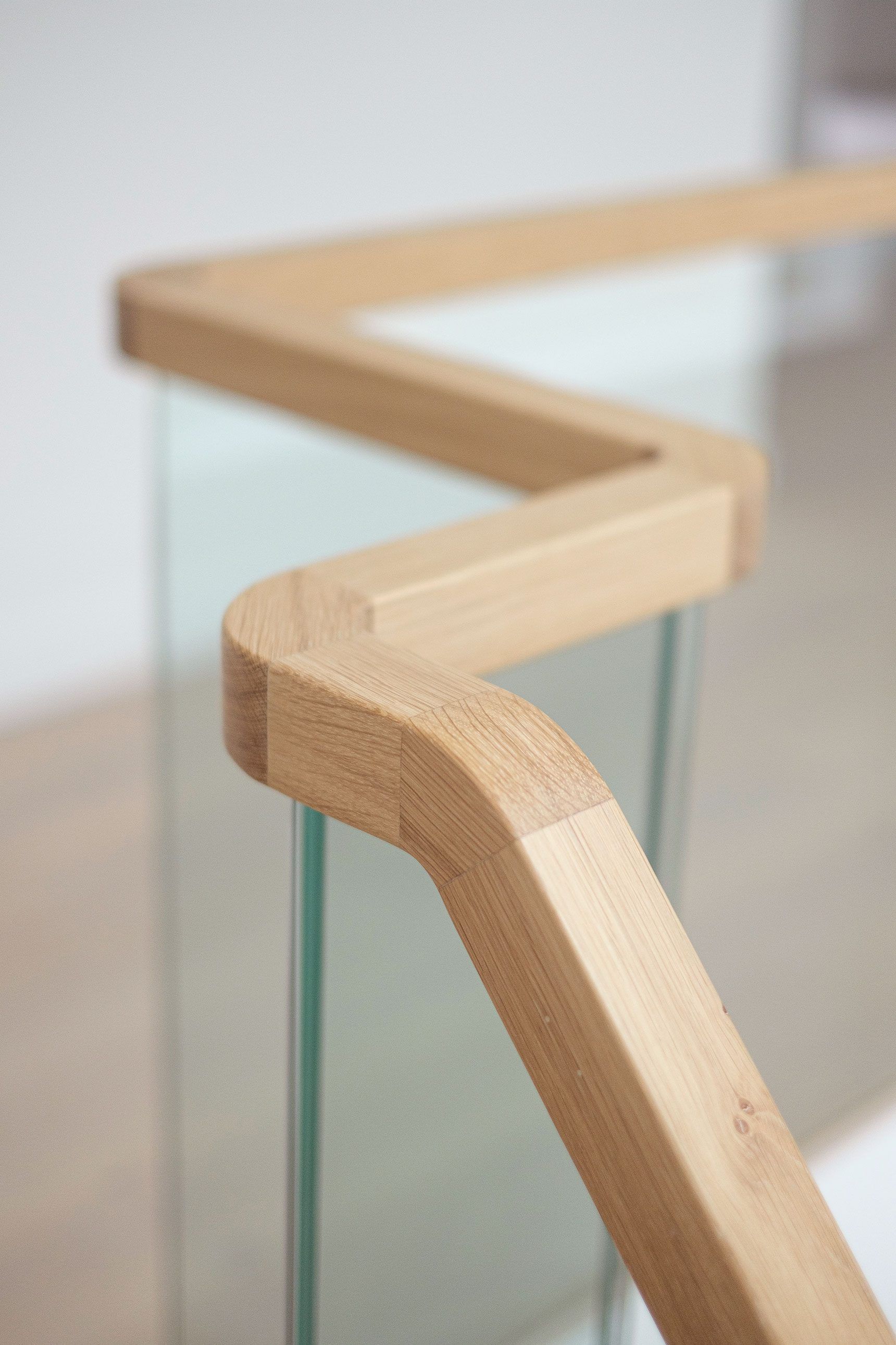 Square section oak handrail on a glass balustrade.