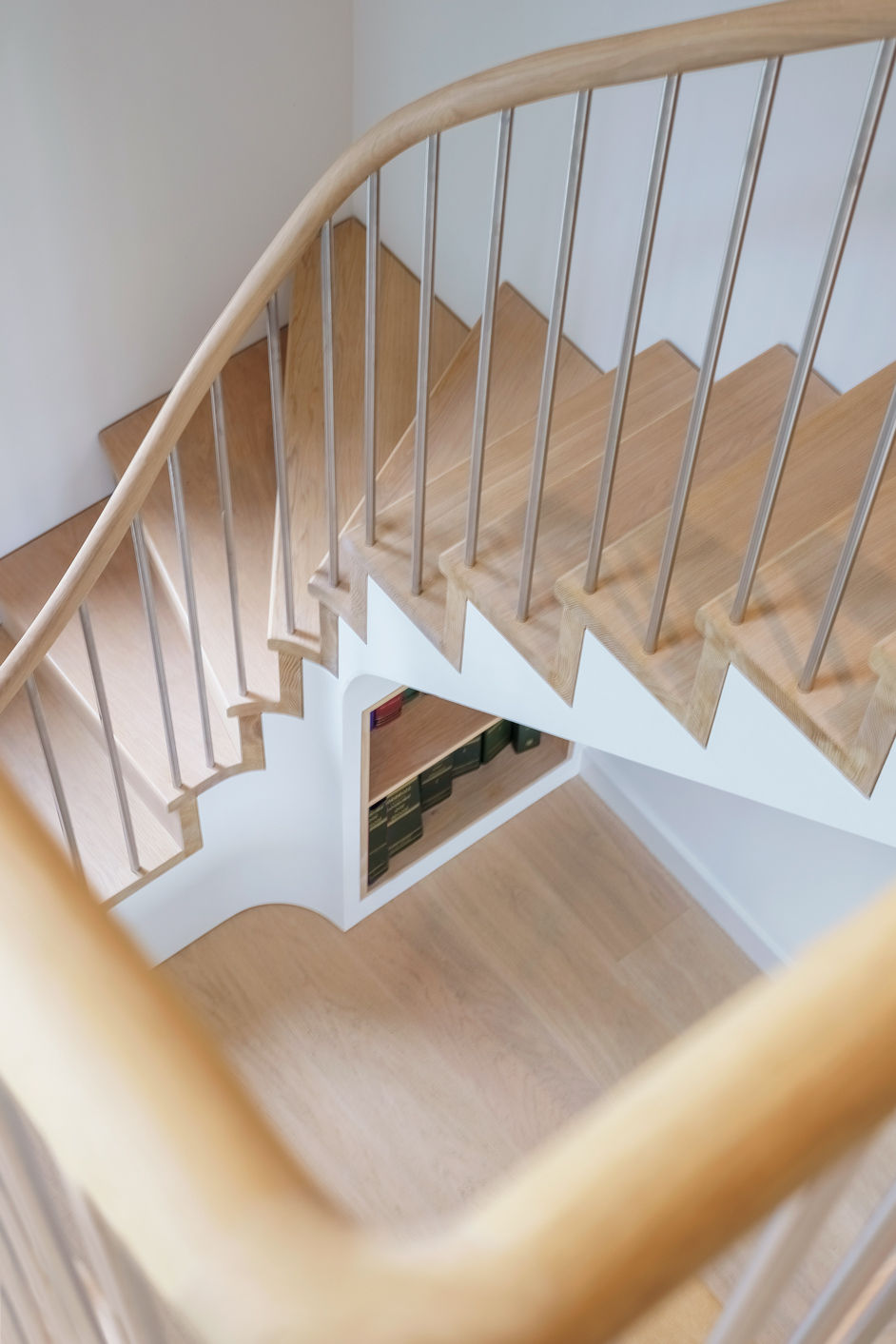 Birds eye view detail of a Staircase with oak treads and risers white stringer and stainless steel spindles.