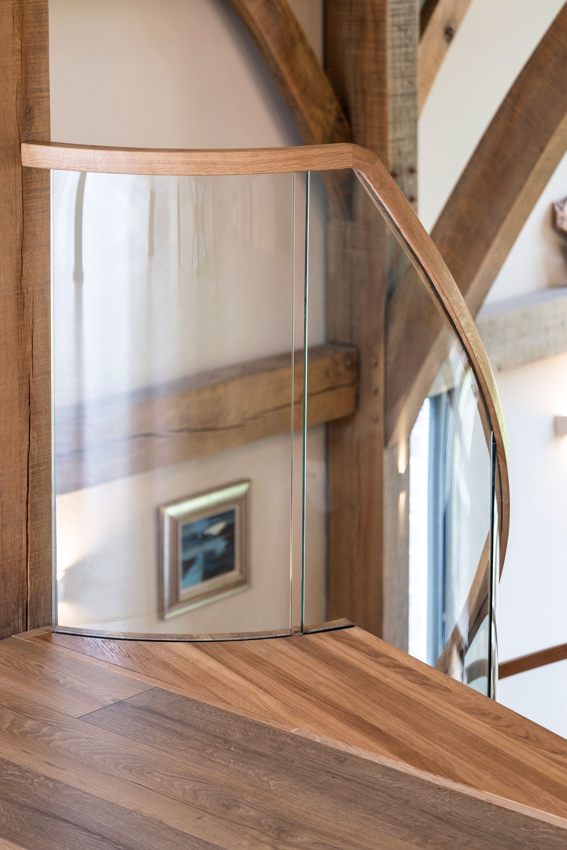Curved oak staircase centrepiece with curved glass in green oak framed, modern home.