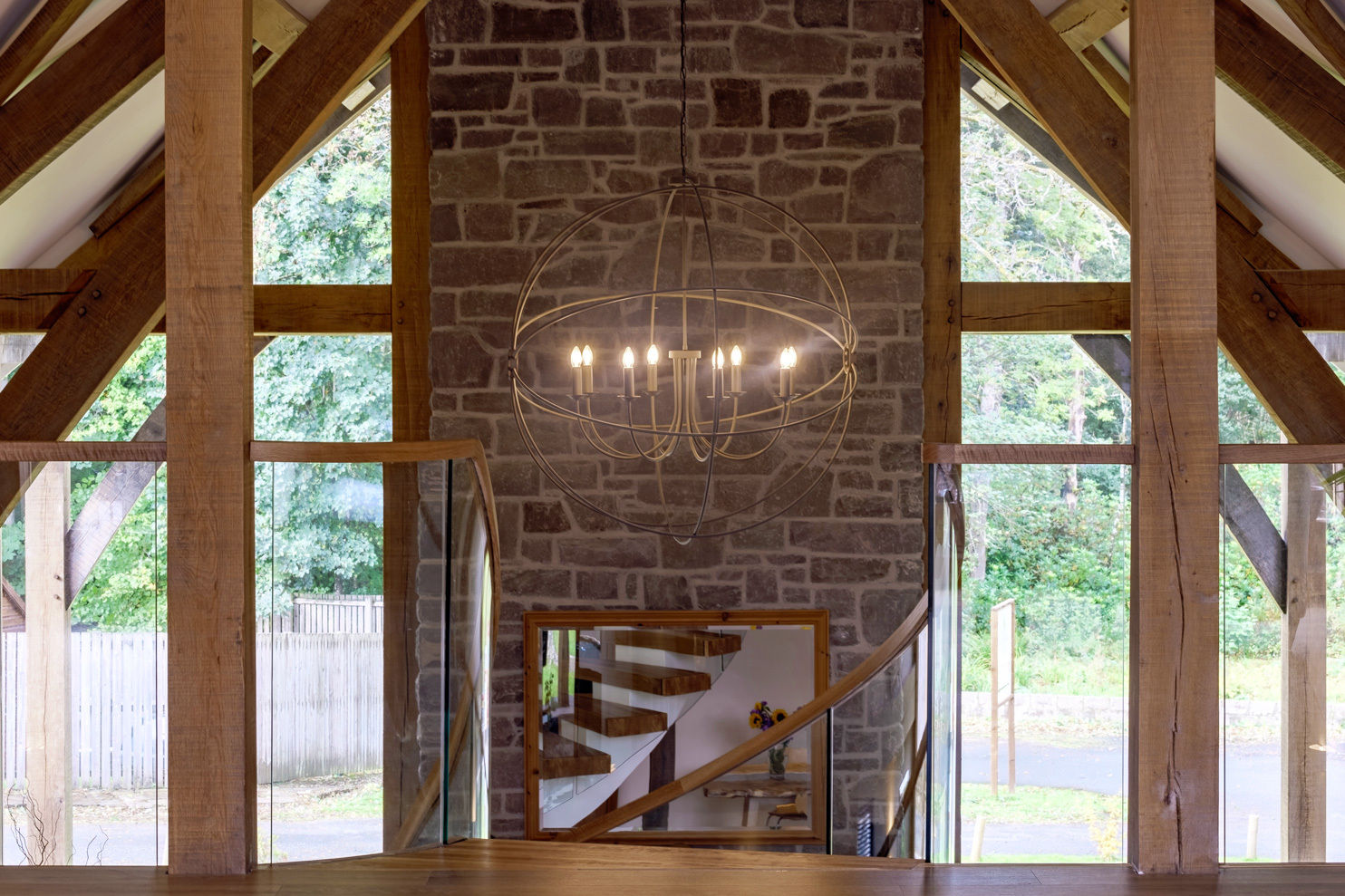 Reflection of curved oak stair centrepiece in mirror in by oak framed home.