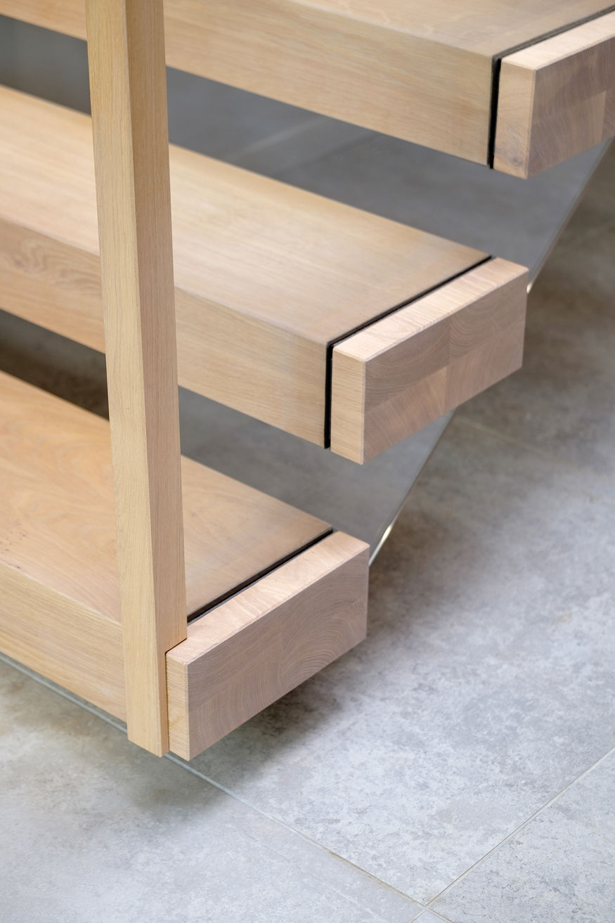 Bottom steps of floating cantilevered staircase with oak treads and glass balustrade. Grey floor tiles.