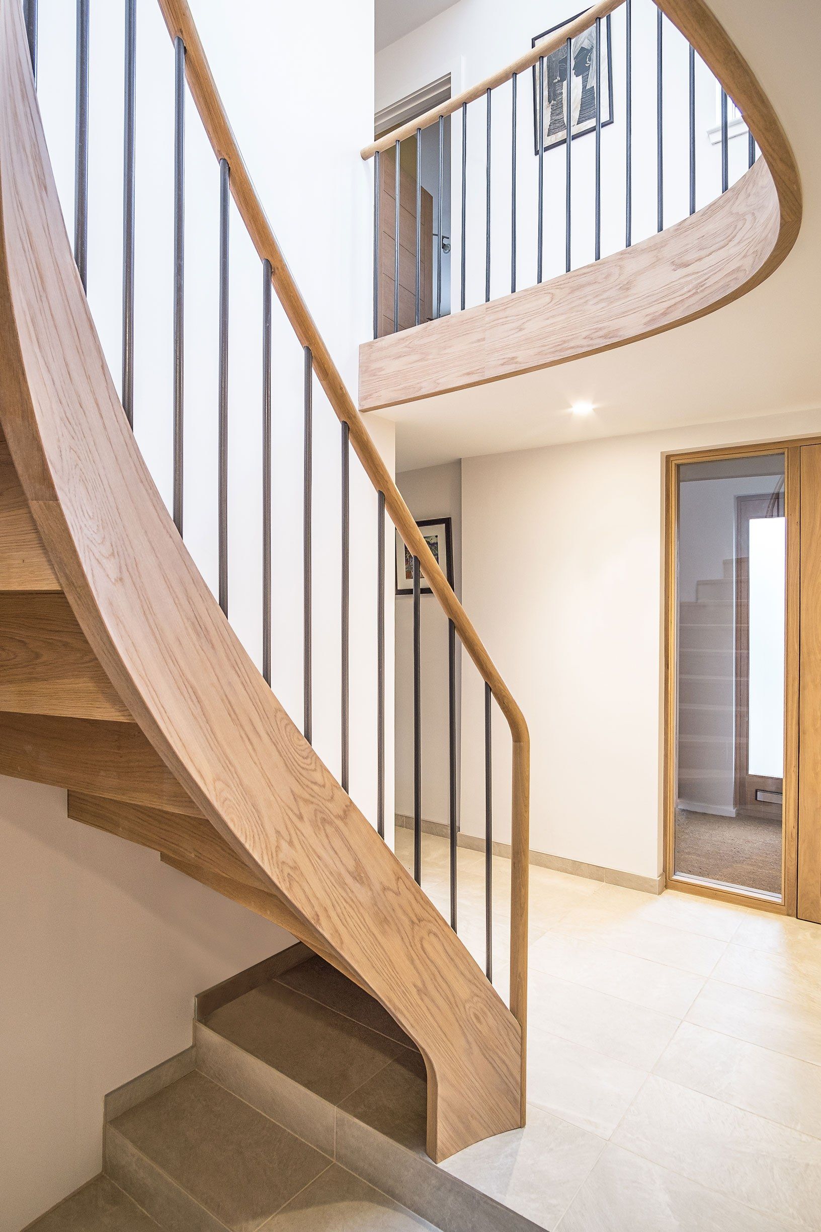 Rear view of feature Elliptical oak stair with iron balustrade spindles and oak handrail.