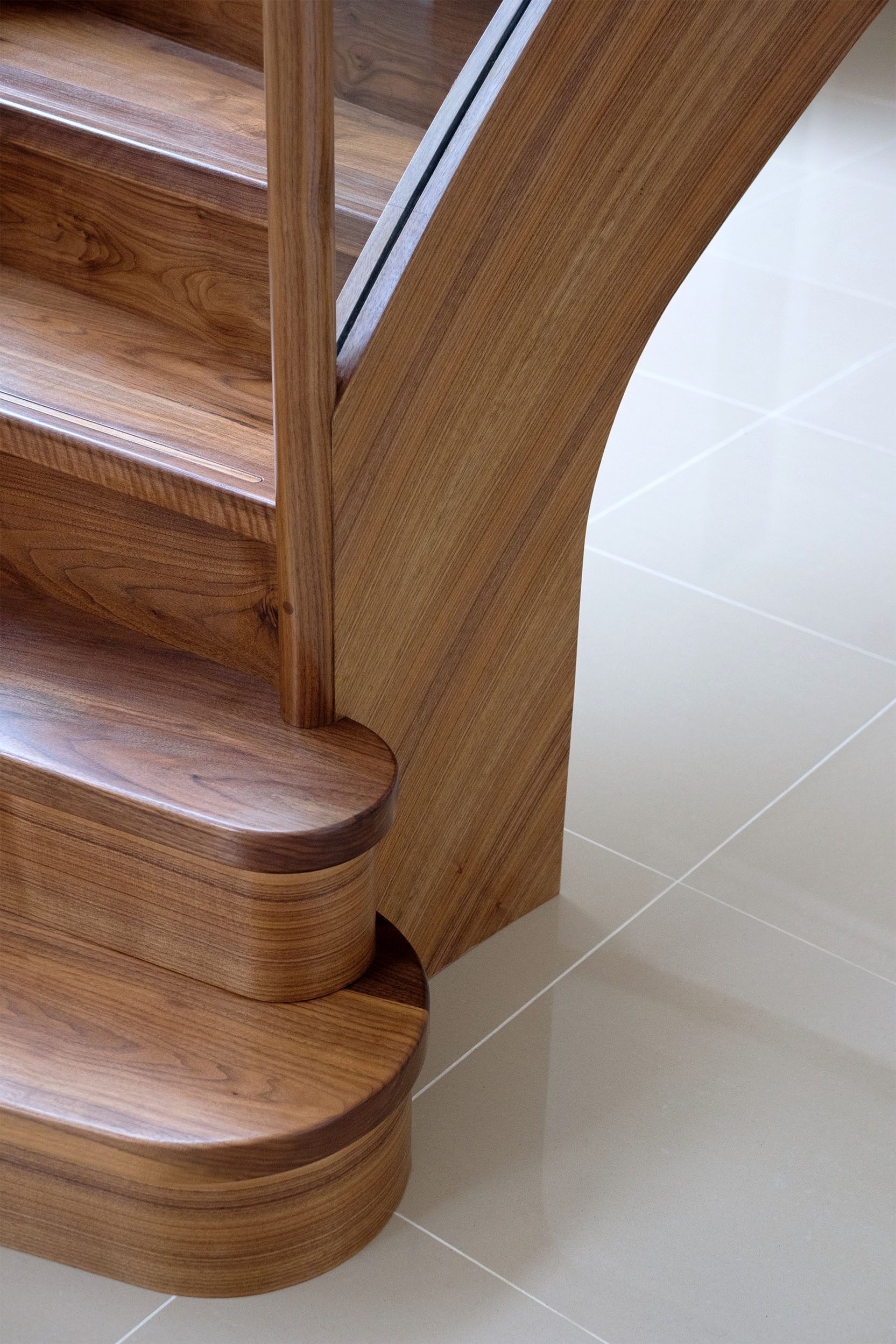 Bottom bullnose steps of sweeping curved walnut stair.