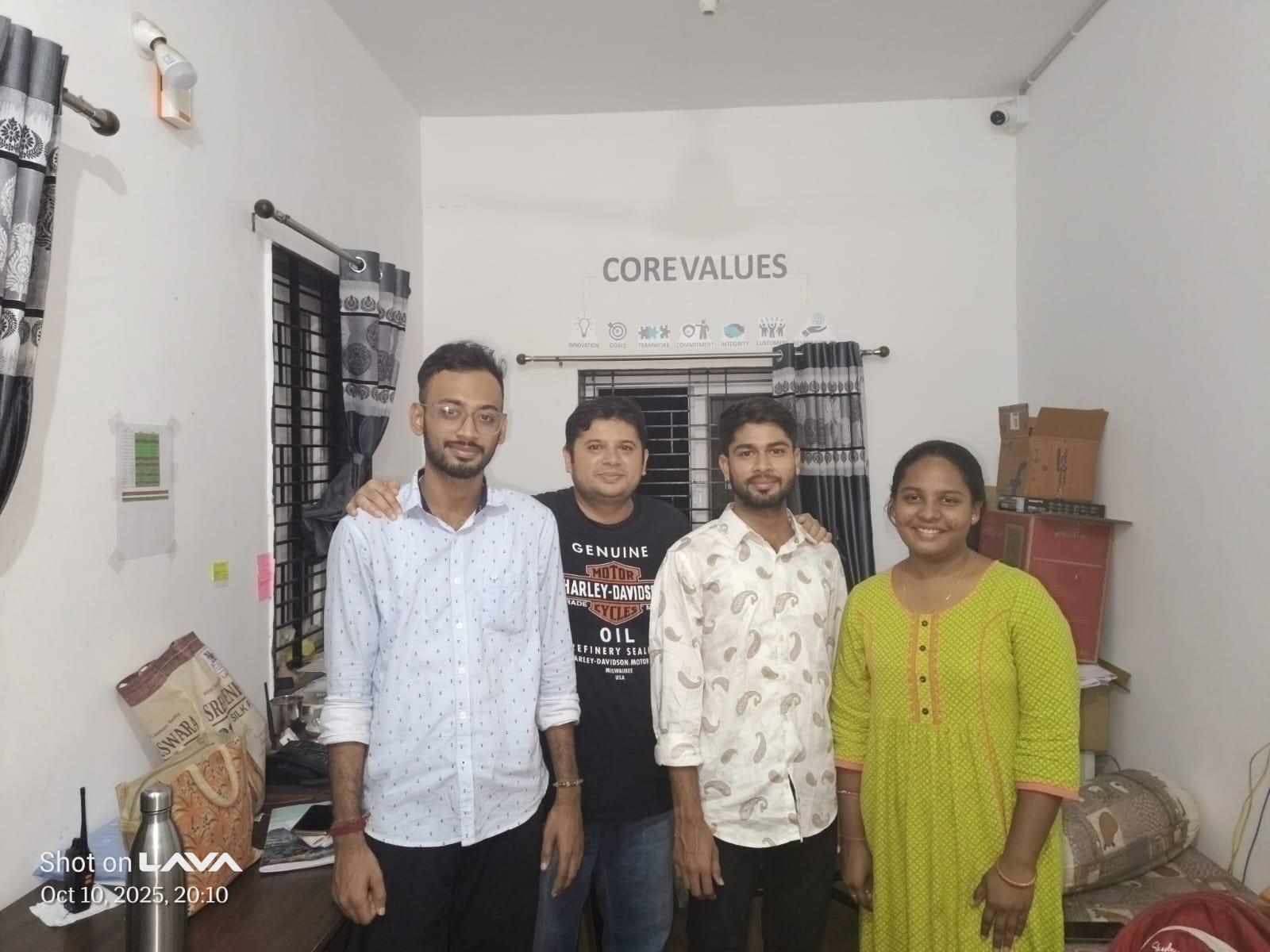 KSAC team members posing together in the office in front of the Core Values wall