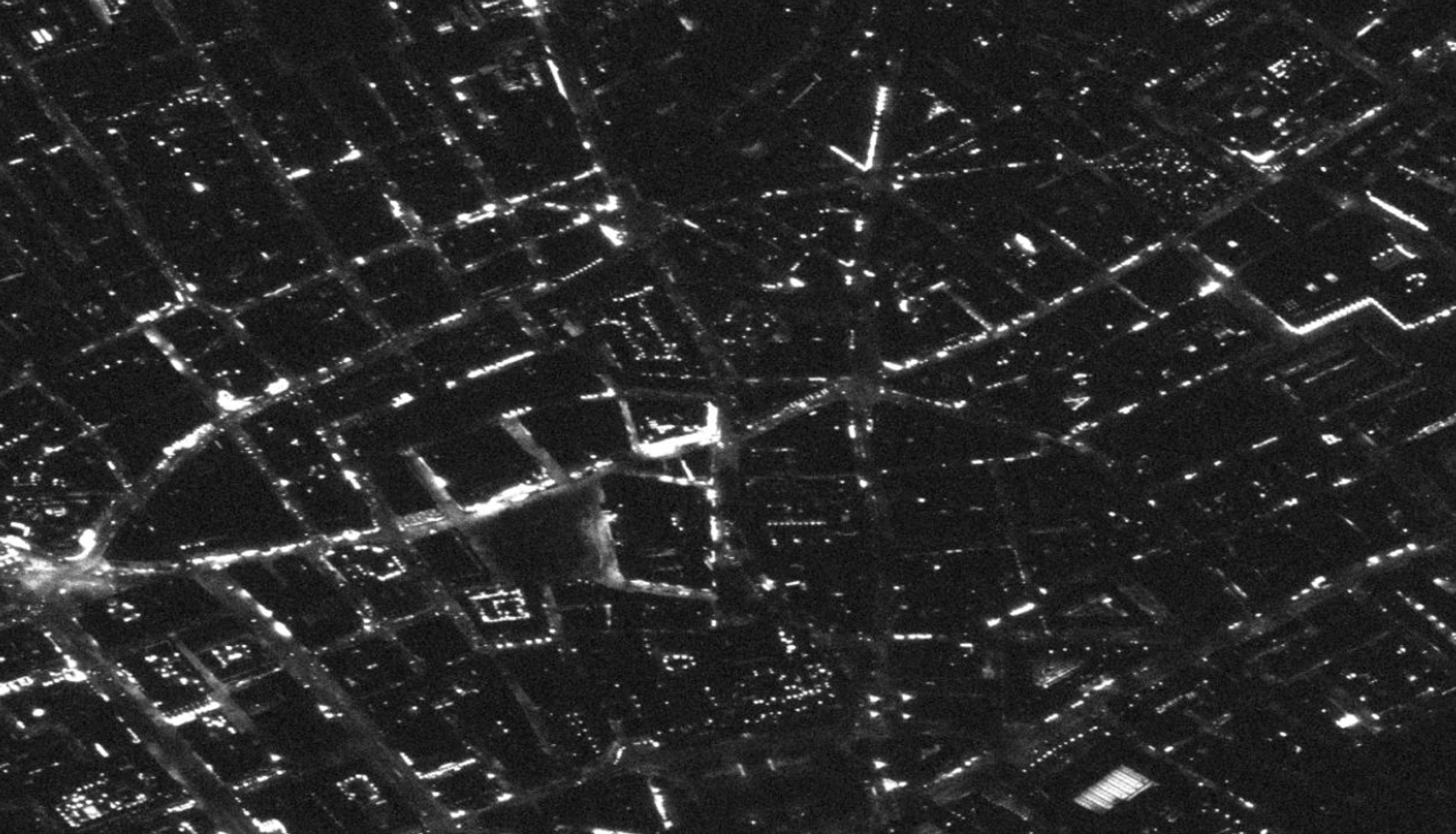At full resolution individual street lights resolve as discrete points, and brightly lit commercial frontages separate from darker residential blocks — what light spill measurement and source classification are built on.