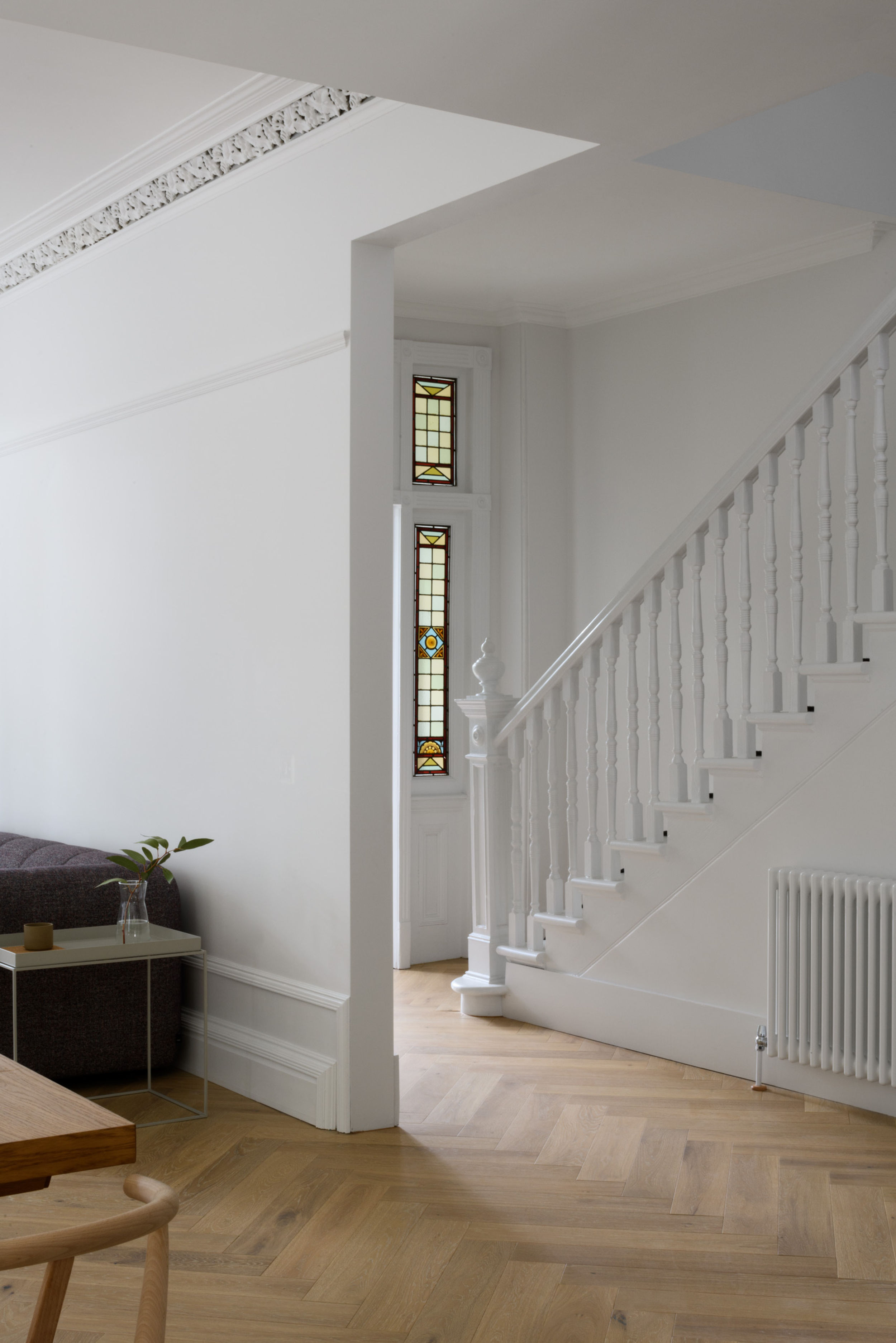 White staircase with stained glass window in background