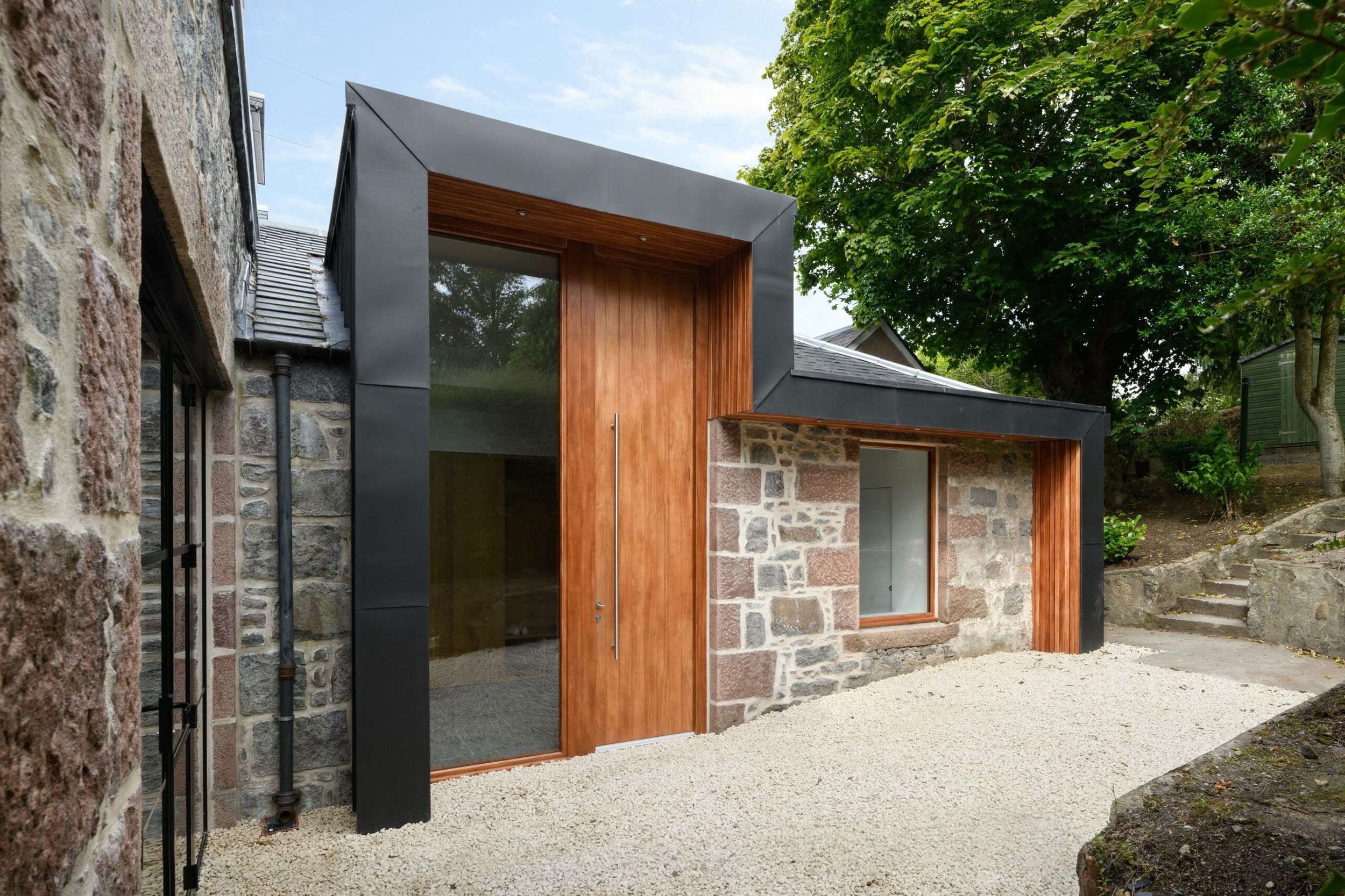 Front entrance with custom made 3.5 metre high Accoya front door with a timber and black zinc extension entrance canopy.