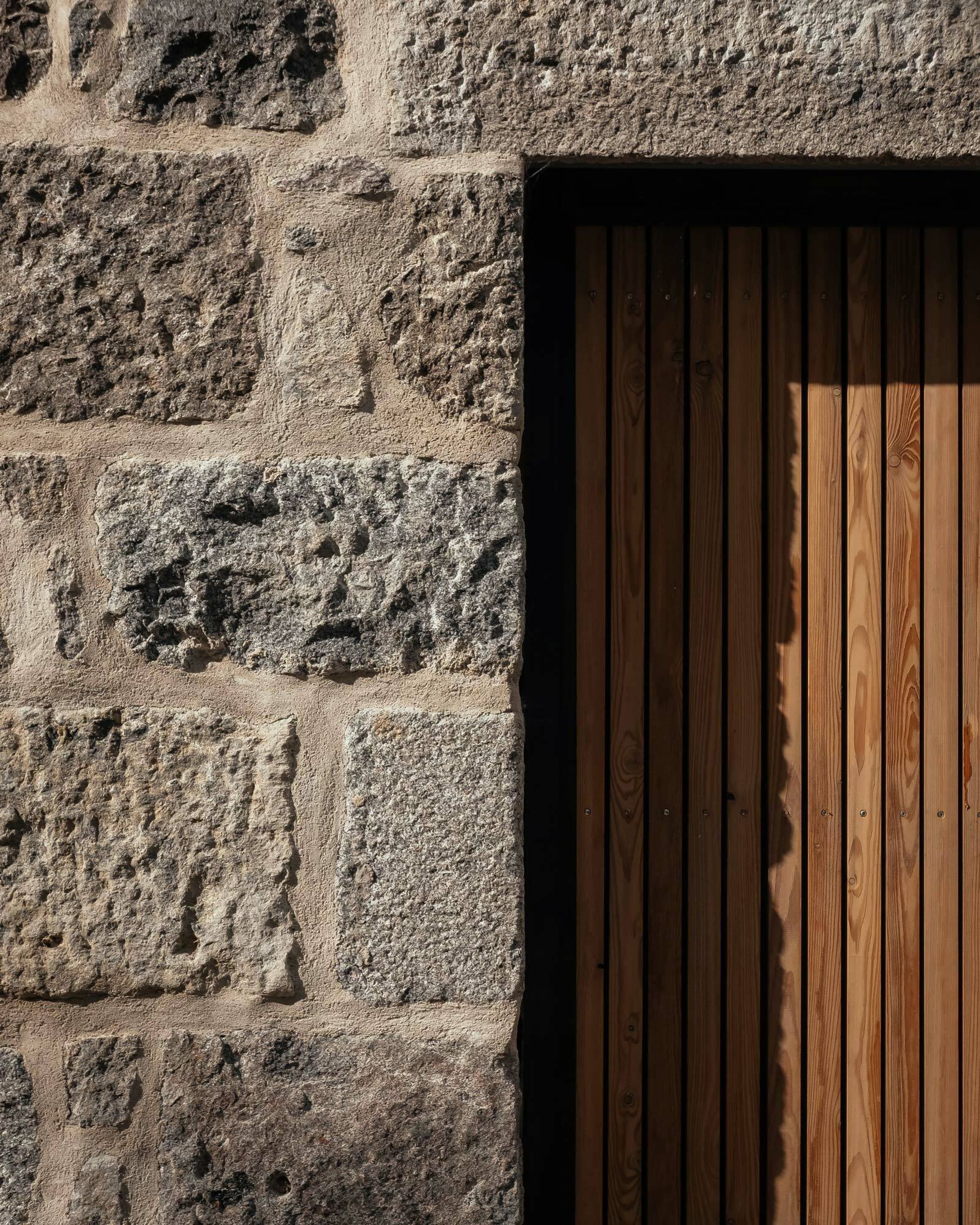 A close up showing granite stone and timber cladding juxtaposed.