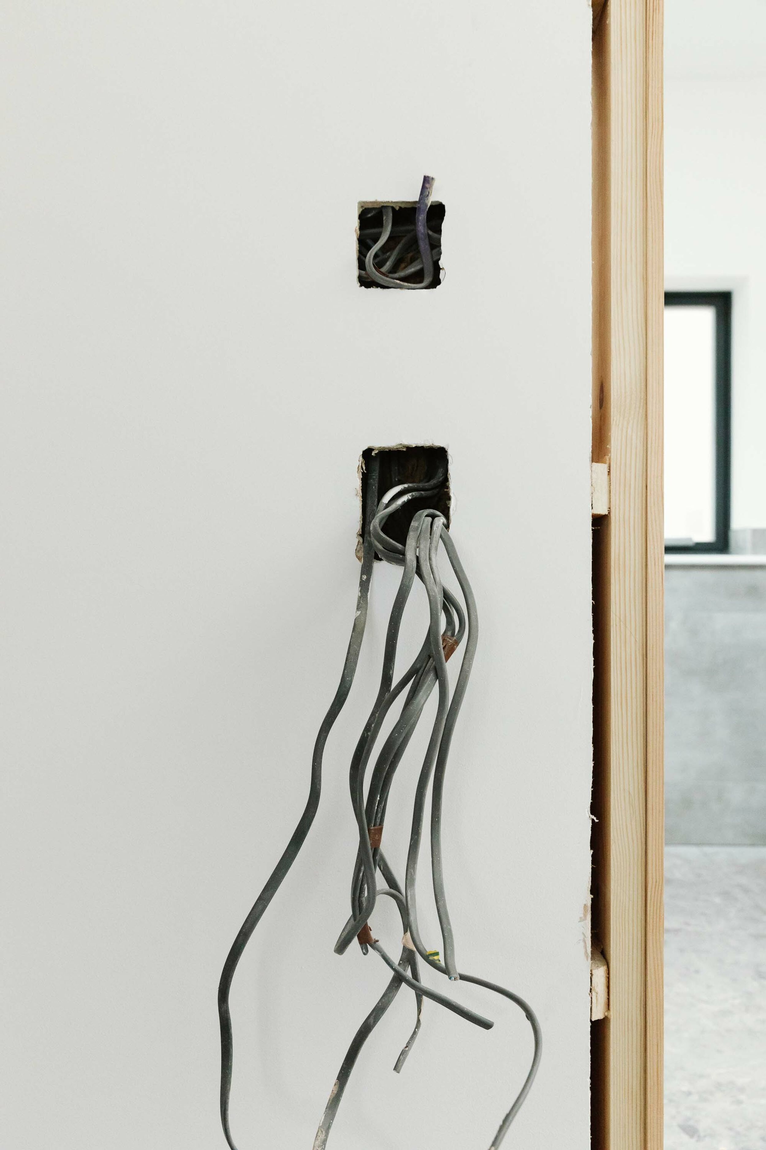 Close up shot of electrical cables poking through holes in the walls, where electrical sockets will go.