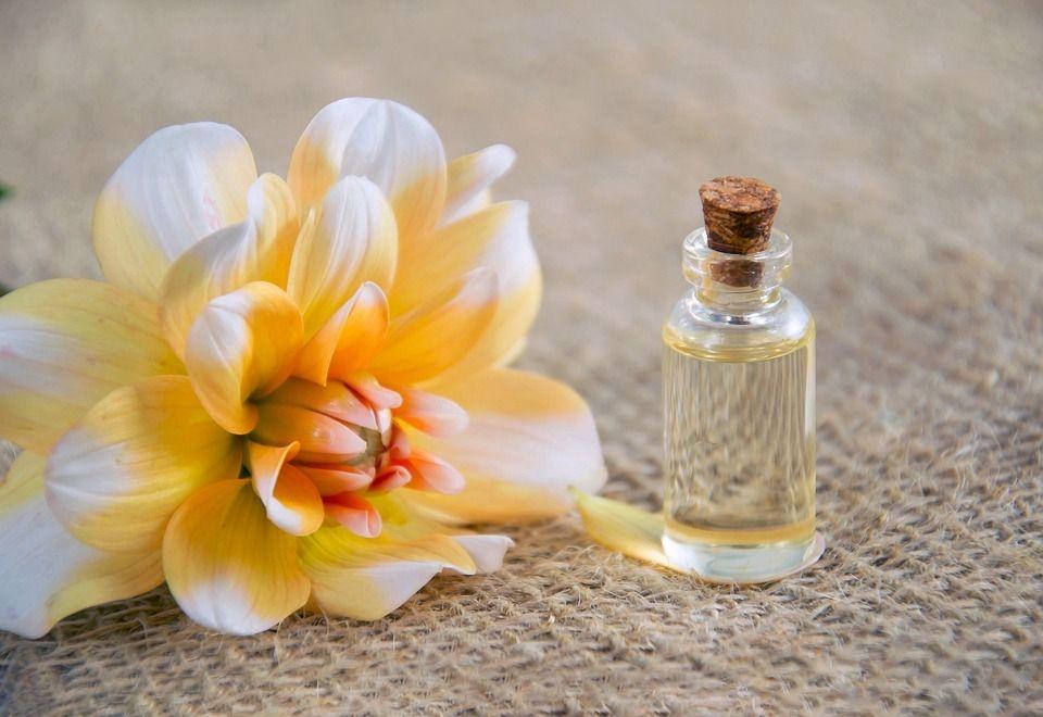 aromaterapia para levantar el ánimo frasco de aceite esencial junto a una flor amarilla