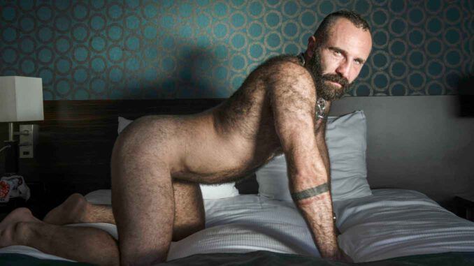 CERF behaarter, baertiger Mann auf dem Bett