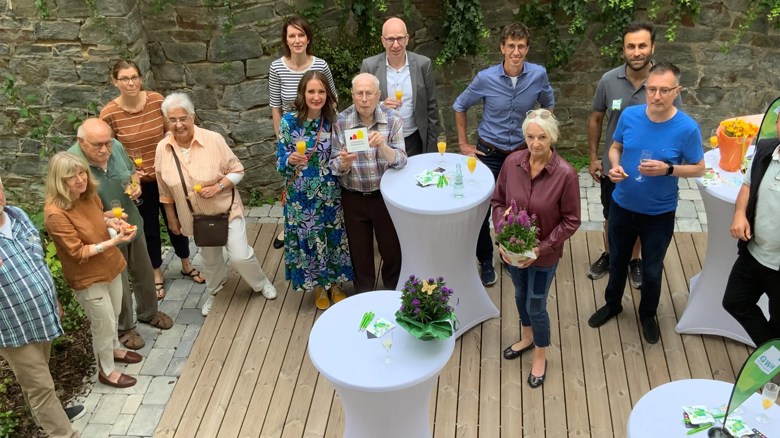 Gruppenbild der GWH-Mitarbeiter, Projektbeteiligten und Mieter zur Erföffnungsfeier des neuen Innenhofs