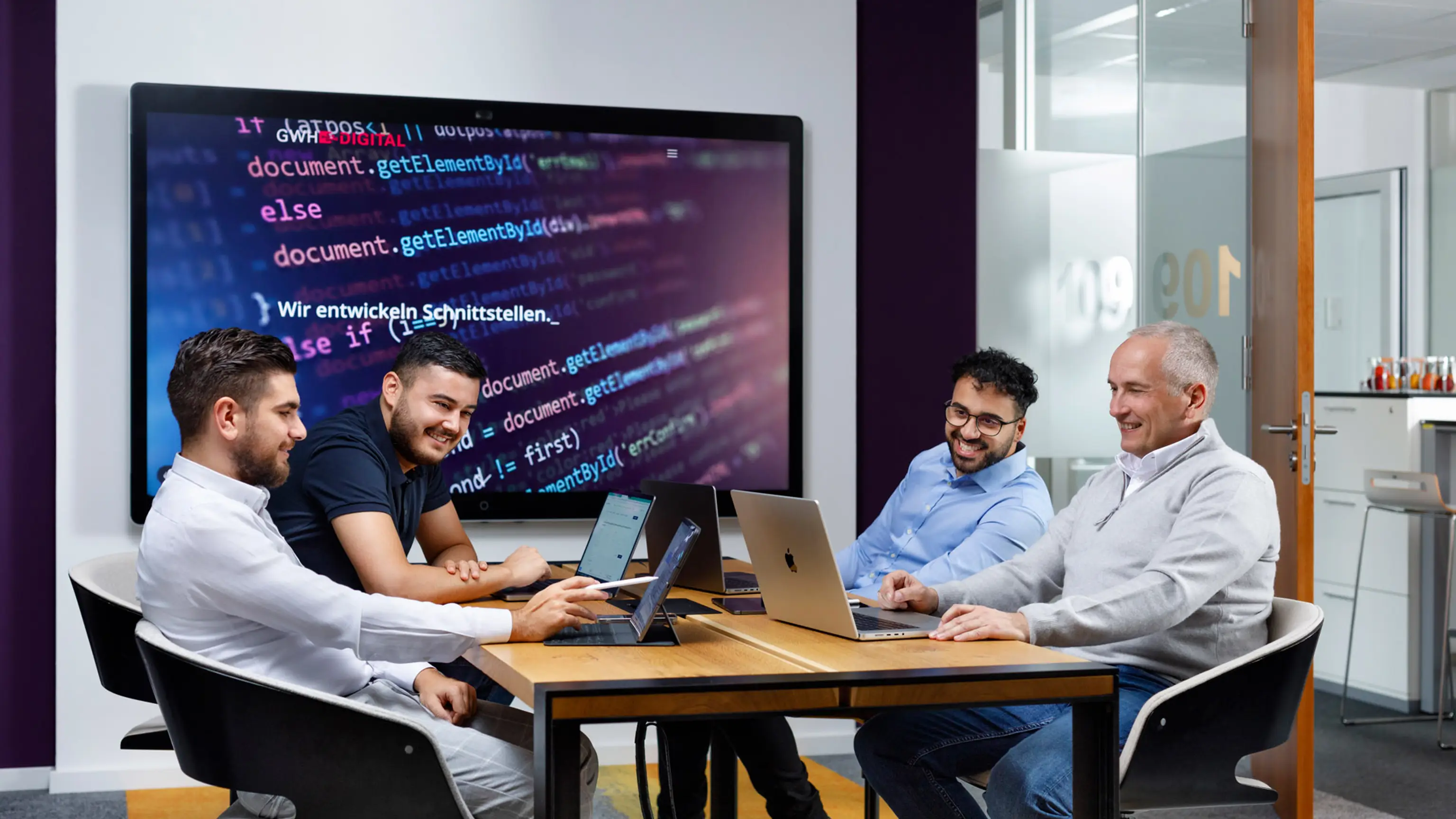 Mitarbeiter der GWH Digital sitzen im Meetingraum
