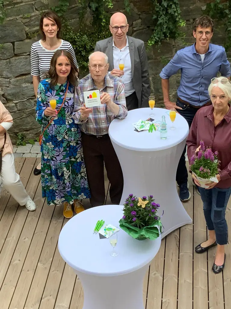 Gruppenbild der GWH-Mitarbeiter, Projektbeteiligten und Mieter zur Erföffnungsfeier des neuen Innenhofs