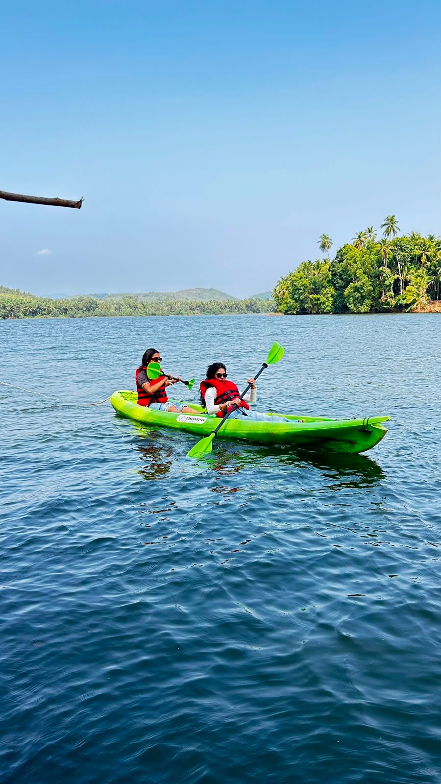 Two paddlers in a tandem kayak on the calm Sharavathi backwaters near Honnavar