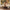 A woman supports a toddler standing on a cream sectional sofa
