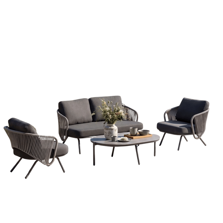 Cutout outdoor set with a sofa, two dark chairs, and a round coffee table on black