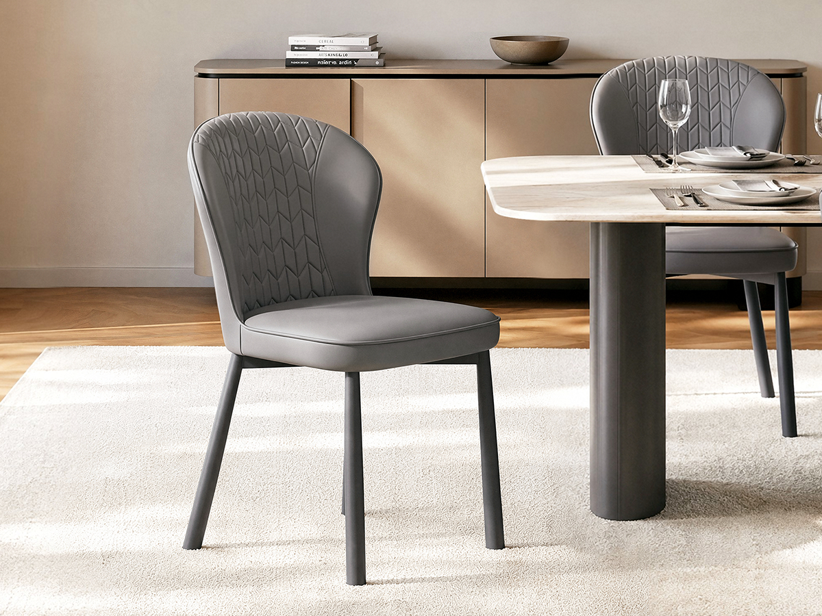 Two gray dining chairs have rounded backs with geometric stitching, Dark tapered legs support each chair