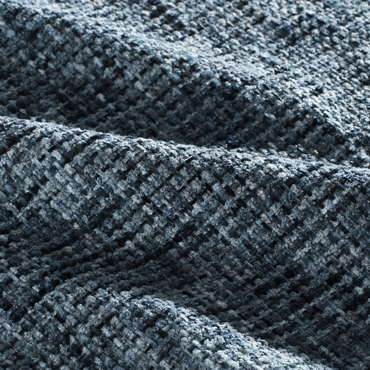 A blue-gray woven surface forms deep folds and shows a coarse multitone texture