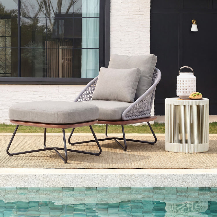 Gray cushioned lounge chair and small table beside a pool