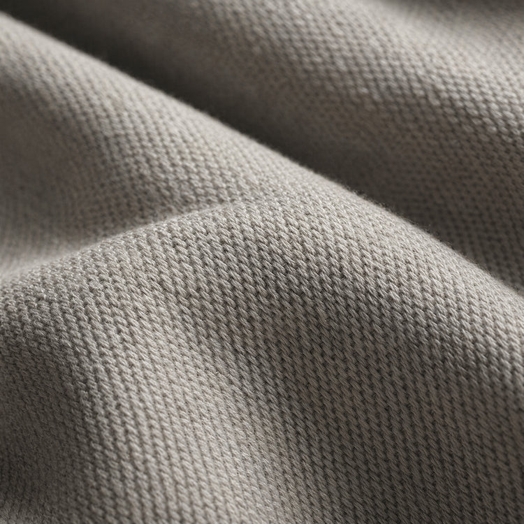 Pale gray fabric shows dense knitted loops across several softly draped folds