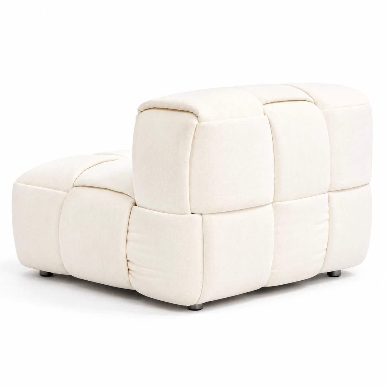 An ivory padded armchair appears from a rear three-quarter angle, Segmented upholstery wraps its back and rounded arms