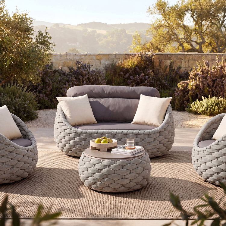 Two matching chairs flank the central loveseat, A low round piece stands in front