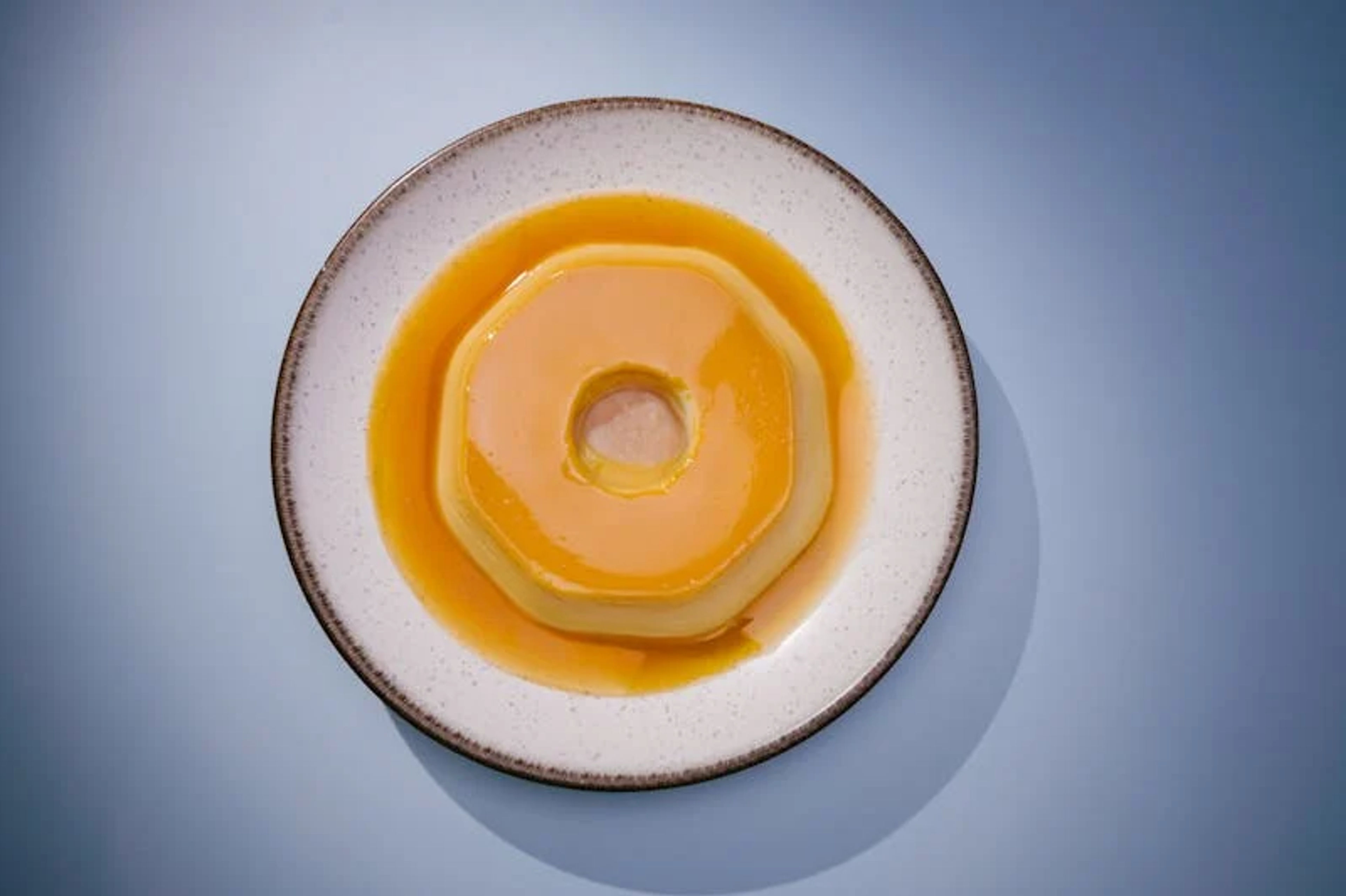 Porción de flan napolitano con una capa brillante de caramelo líquido.