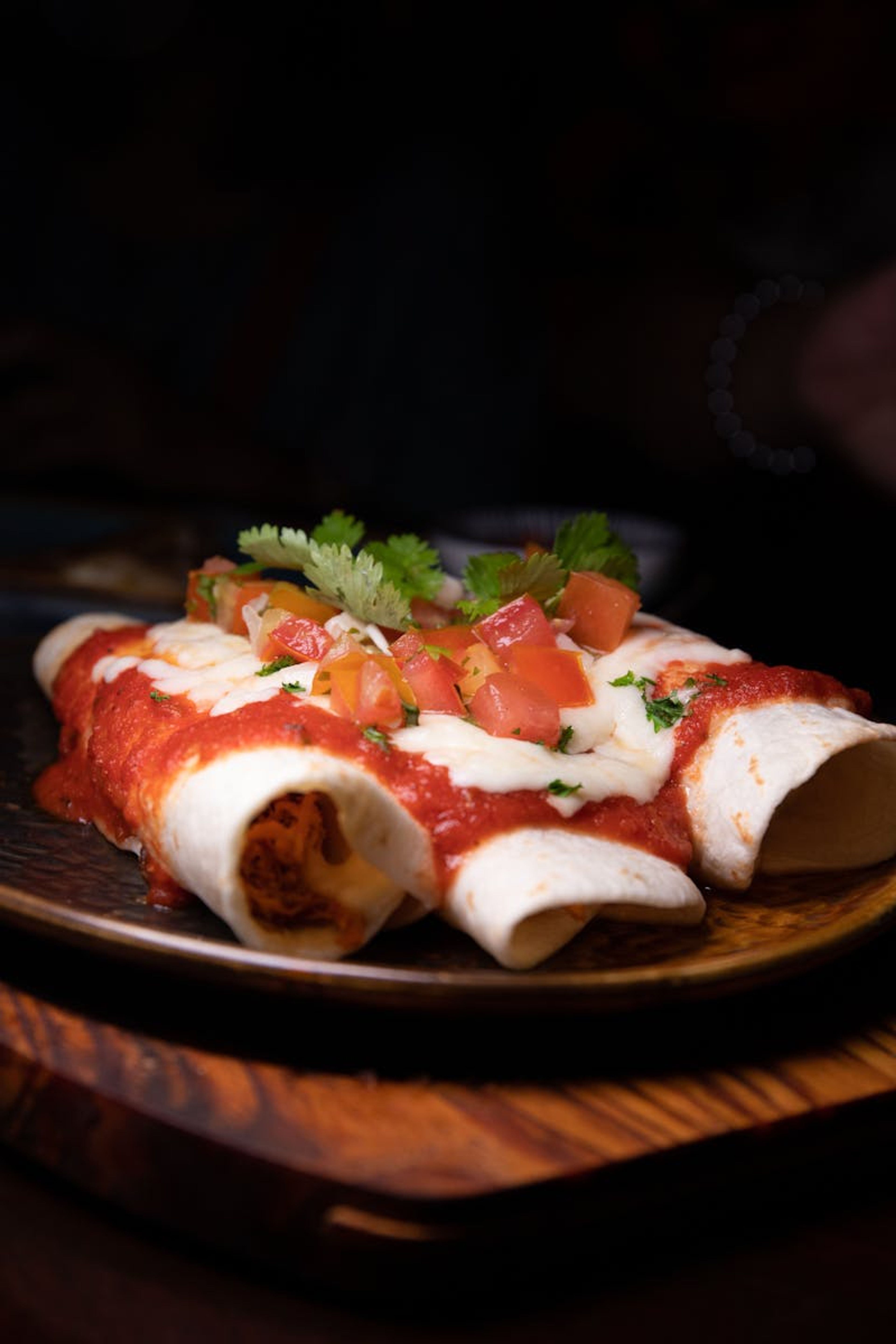 Enchiladas bañadas en salsa verde cremosa con queso gratinado.