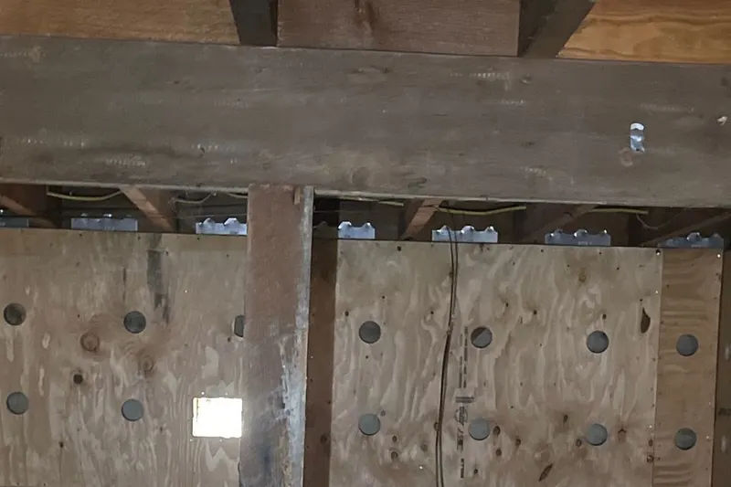 Plywood wall reinforcement installed beneath exposed wood floor framing