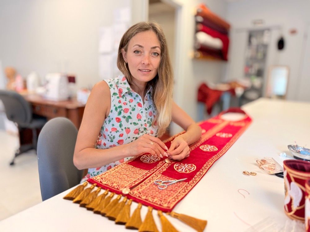 Hand-finishing an embroidered epitrachelion in our Florida atelier — the same craft used for centuries.