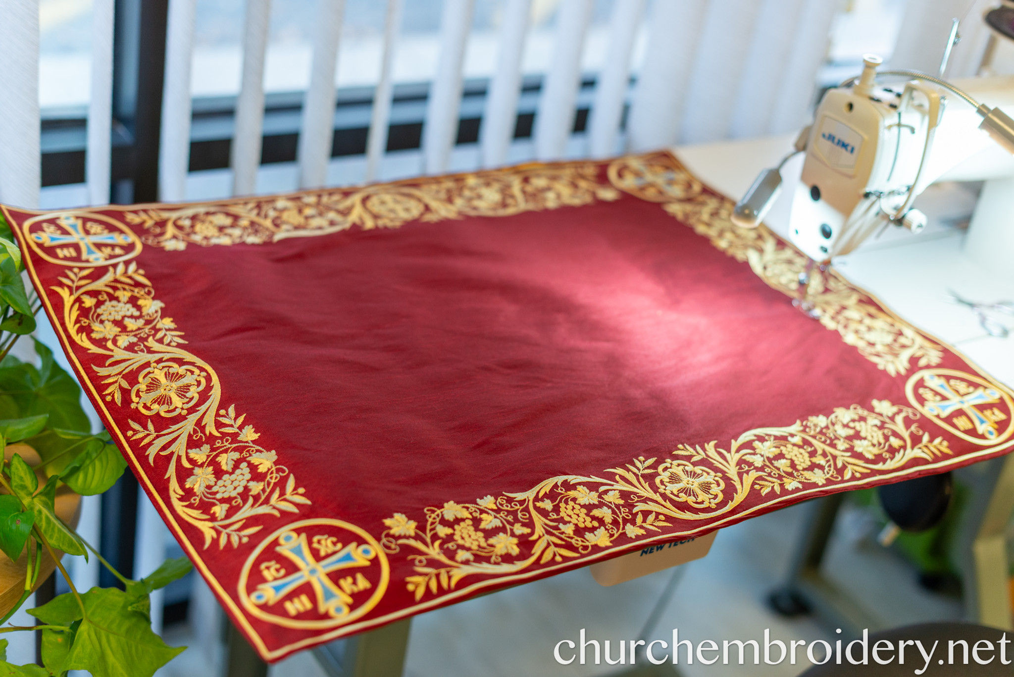 An Orthodox antimins unfolded on the Holy Table, showing the icon of the Burial of Christ and the bishop's signature at the bottom.