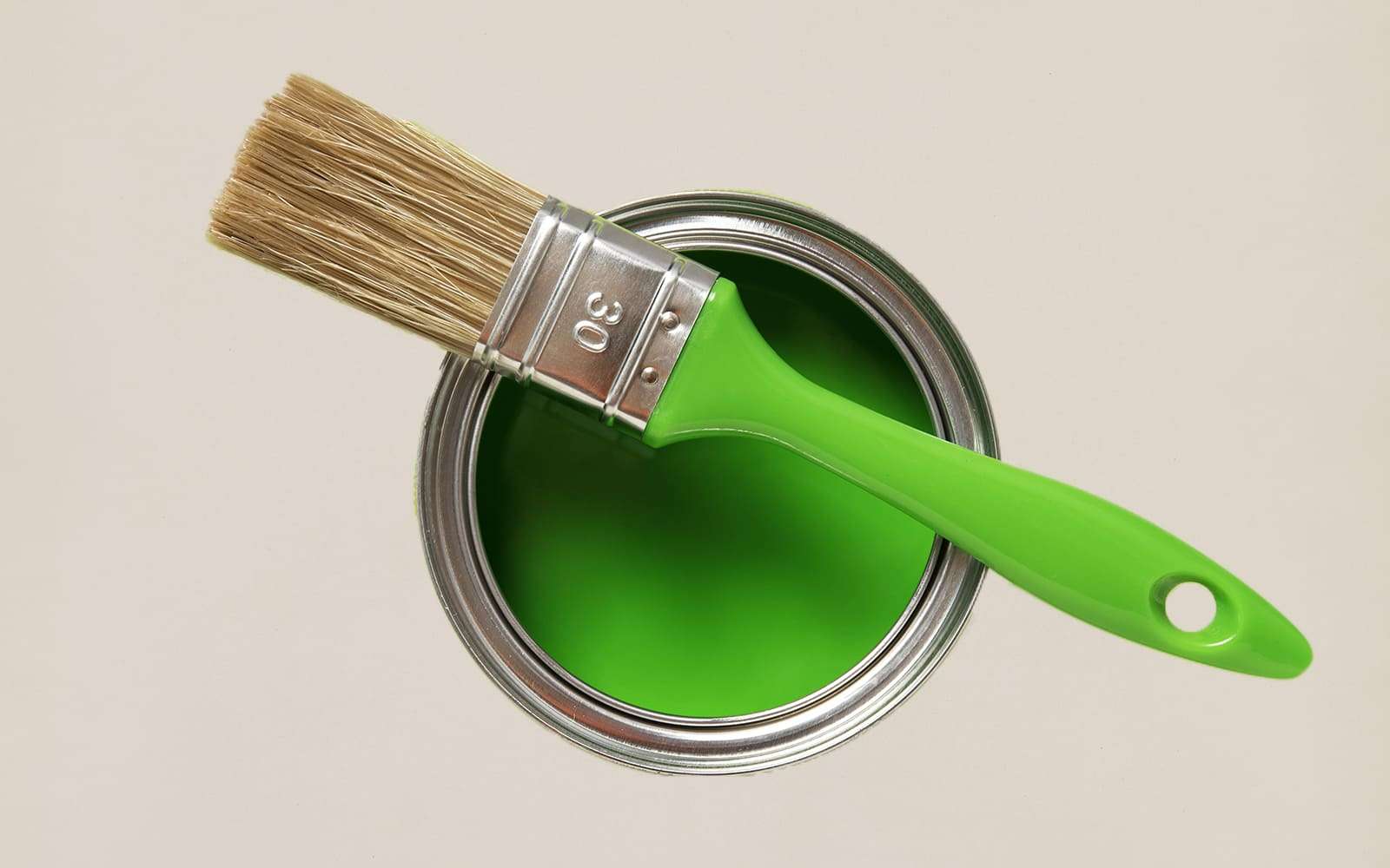Imagem mostrando uma lata com tinta verde dentro e um pincel em cima