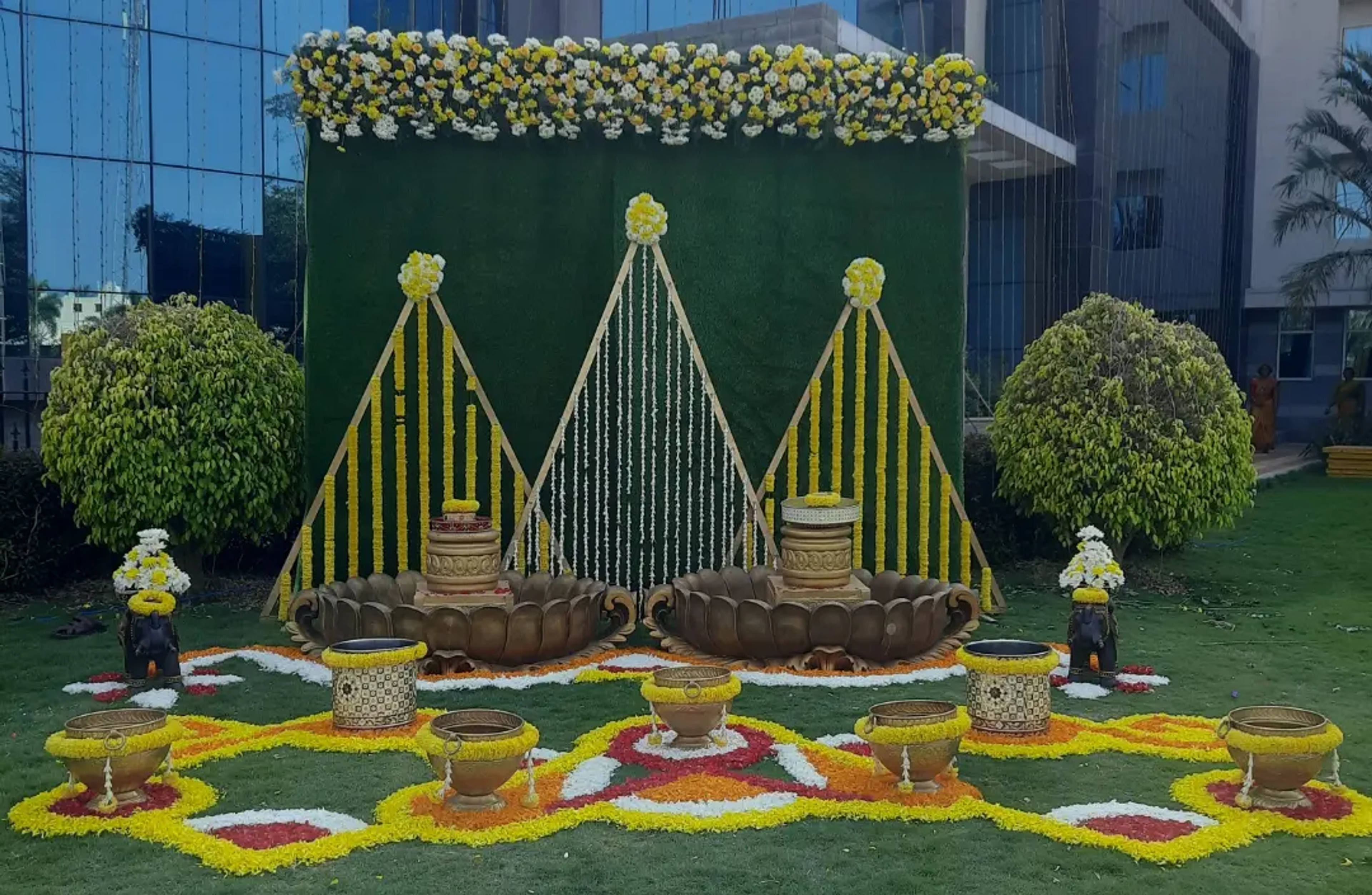 Green and yellow haldi stage with a marigold floor rangoli