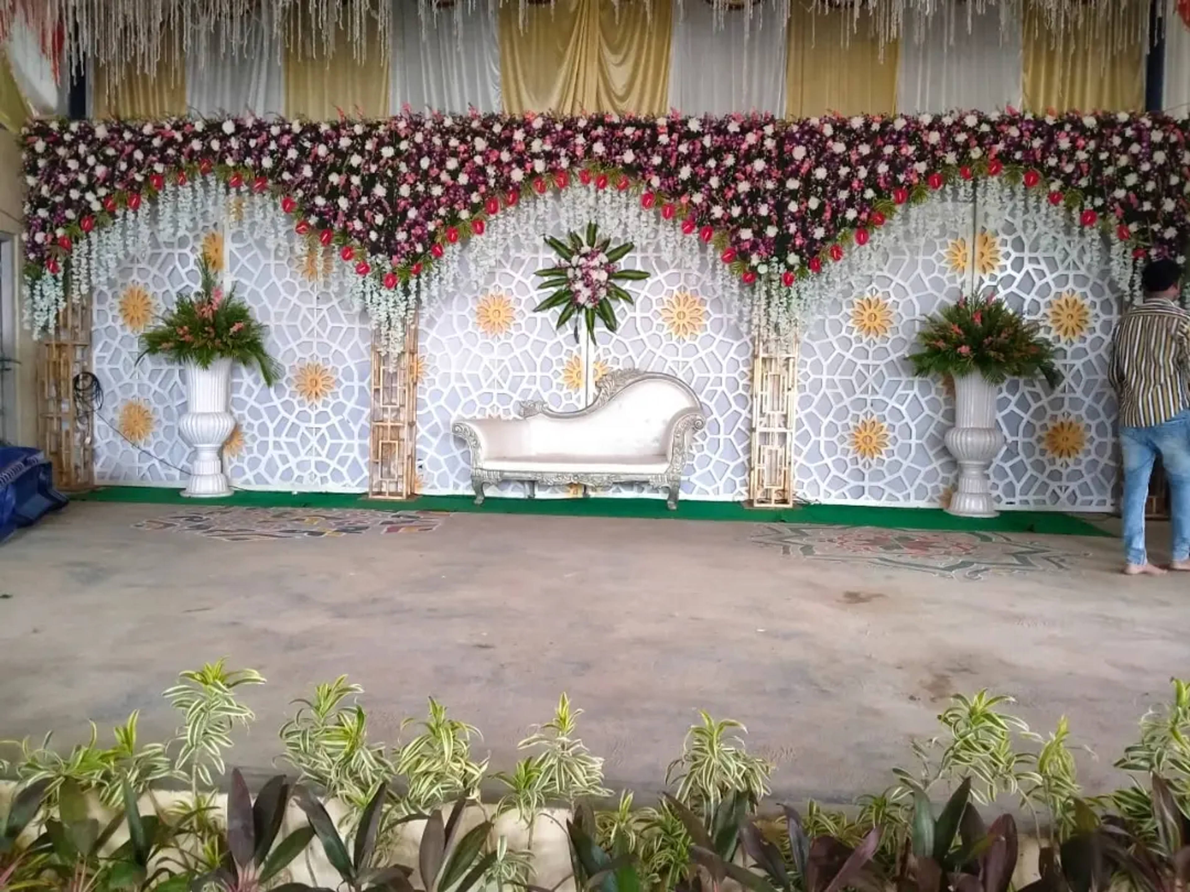 White lattice stage with floral arches and potted greenery
