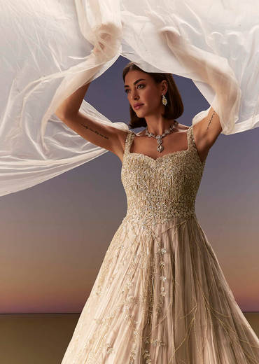 Gold Gown With Pleated Panels And Dramatic Cape