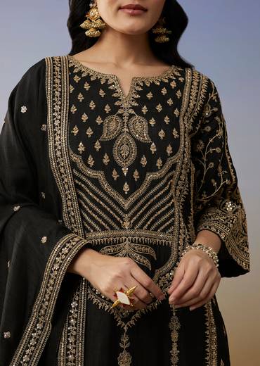 Bold Festive Couple Set – Black Silk Palazzo Suit With Zari Thread And Sequins Work For Her And Black Suiting Jodhpuri Pant Set With Embroidery For Him