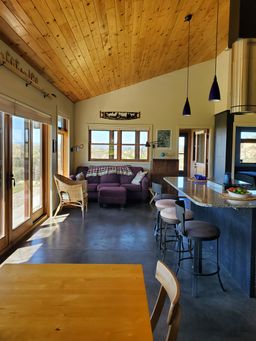 Stained concrete floors for passive solar heating. Pine ceilings made from trees felled and milled on the property.