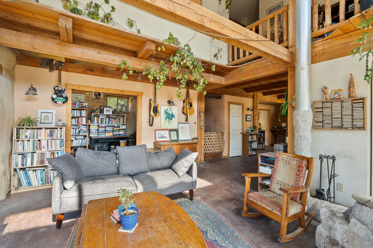 Living area with bedroom/office space in background.