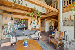 Living area with bedroom/office space in background.