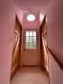 Second floor landing and door to upper deck overlooking pond