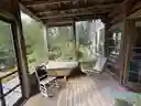 Screen porch with cast iron tub with hot/cold running water; overlooking deck and pond