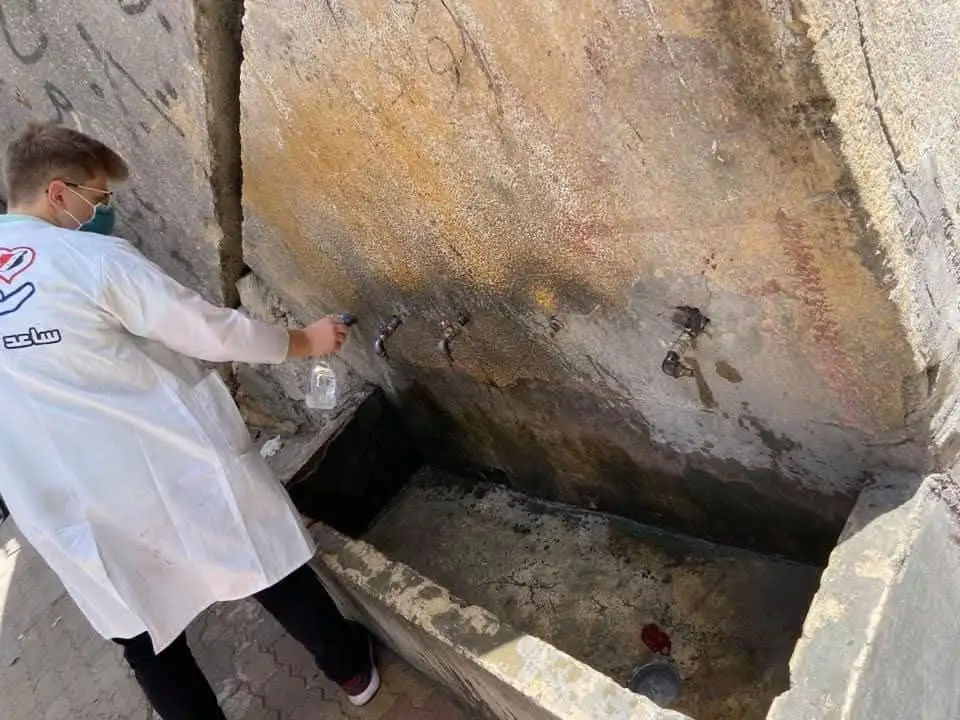 Cleaning public water taps to reduce contamination and support hygiene