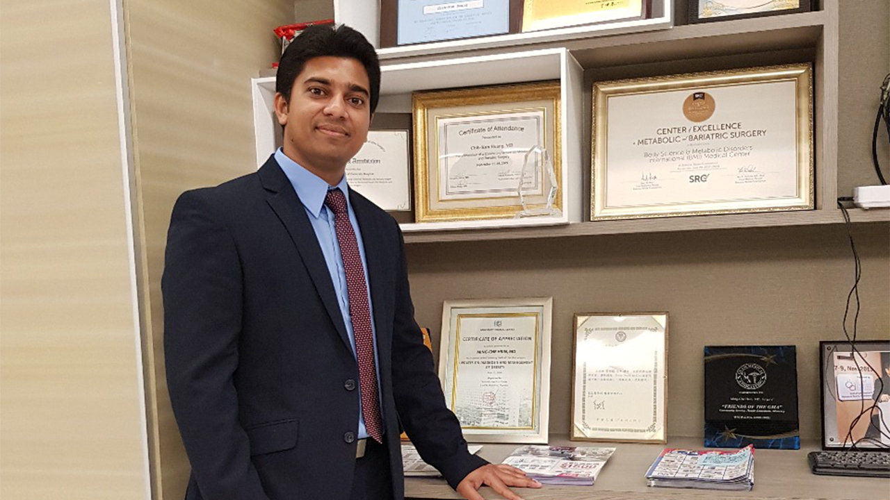 Dr Christopher standing alongside with his degrees Dr Christopher standing alongside with his degrees
