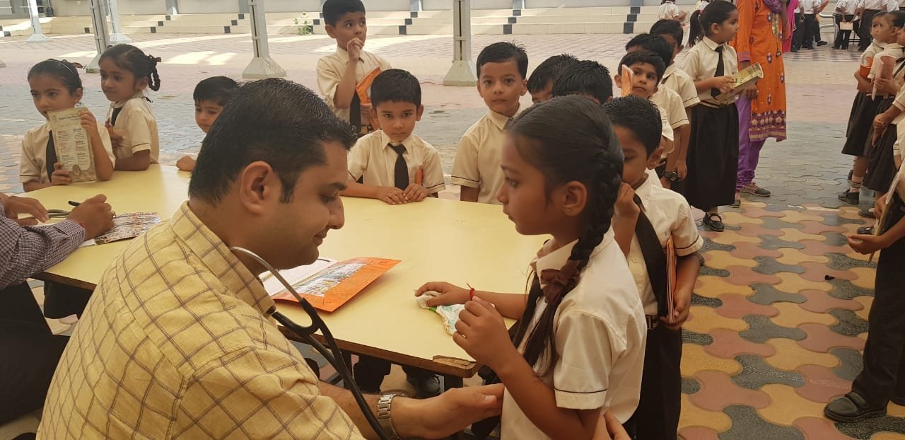 Dr. Dipesh checking up children during the Health Check-up Camp in Sanskar School, Bhuj