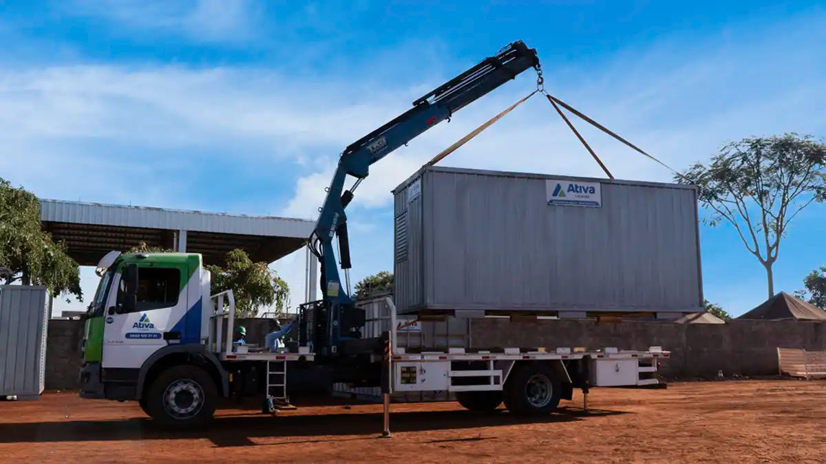 Caminhão munck da Ativa Locação içando um container almoxarifado em chapa galvanizada.